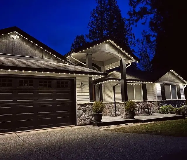 Stone-front bungalow with permanent roofline lighting at dusk